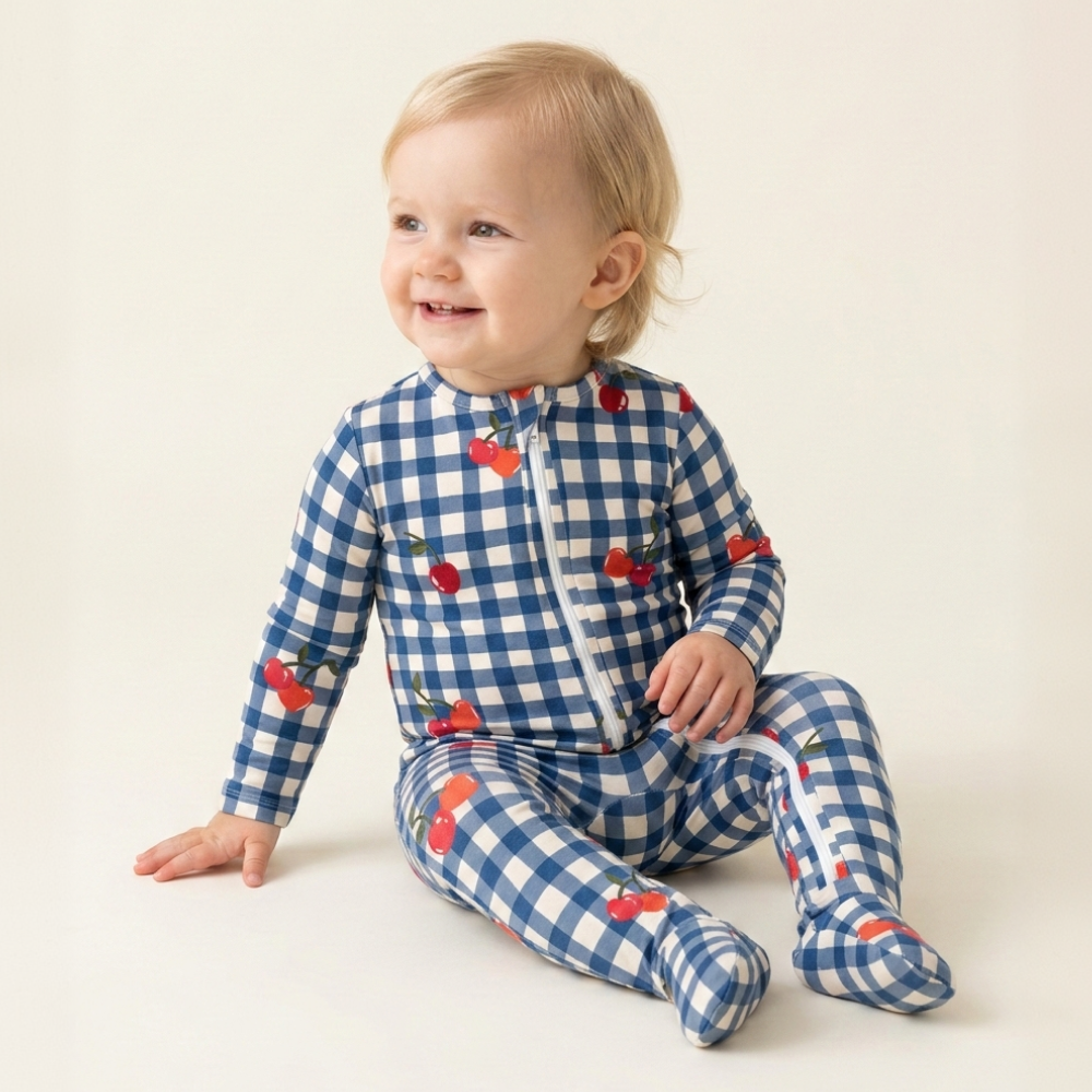 Baby sitting in gingham cherries pajama, smiling